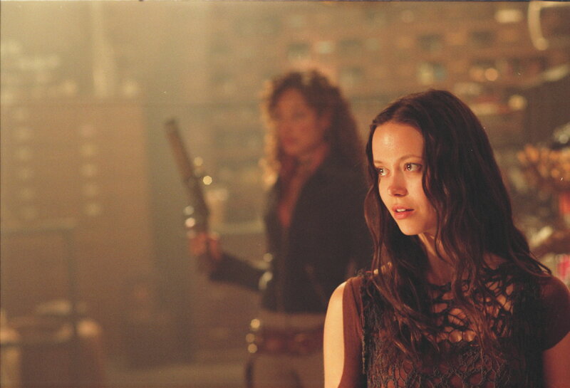 Woman holding gun in smoky room