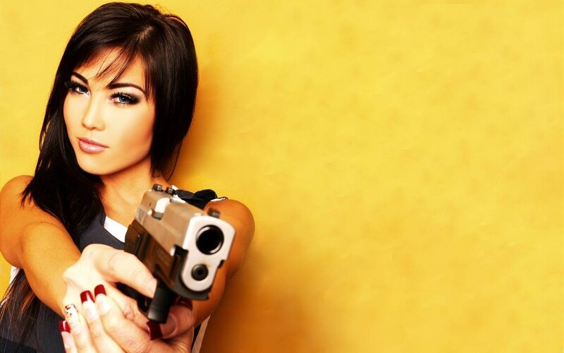Woman Holding Gun — Yellow, Serious