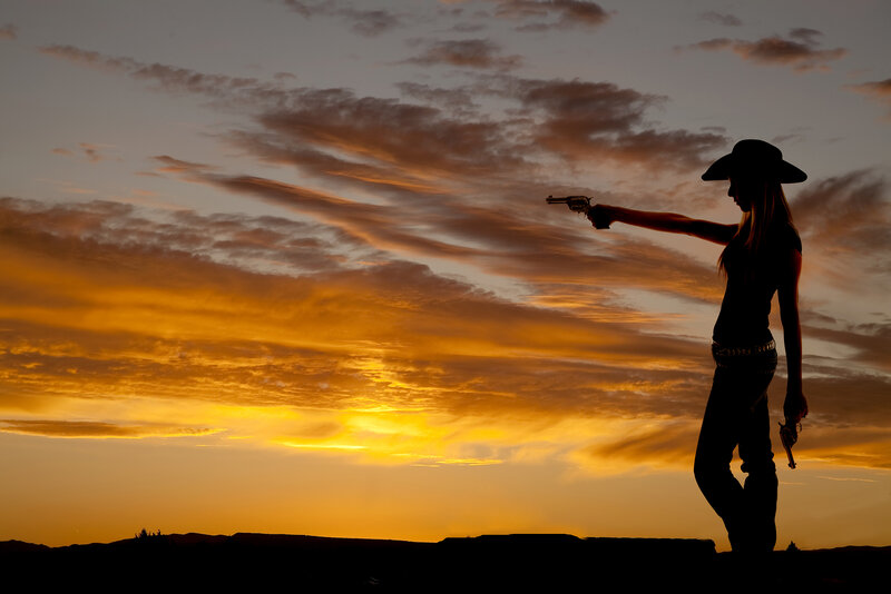 Woman Holding Guns — Orange, Dramatic, Sunset
