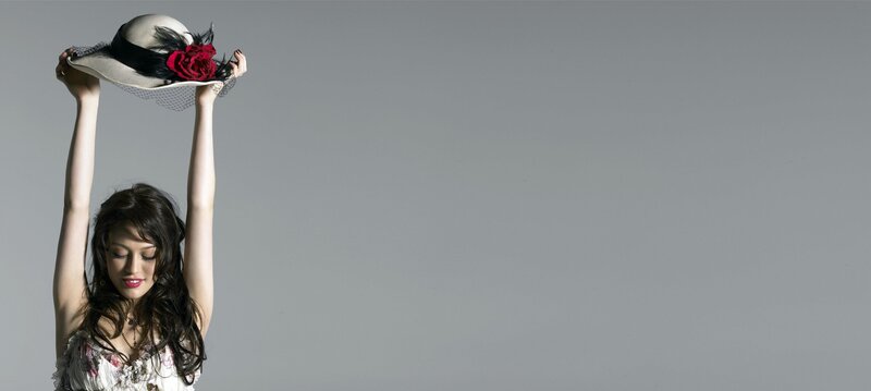 woman holding hat above head