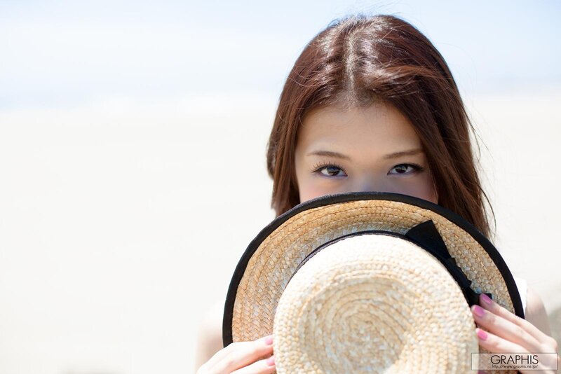 woman holding hat at beach
