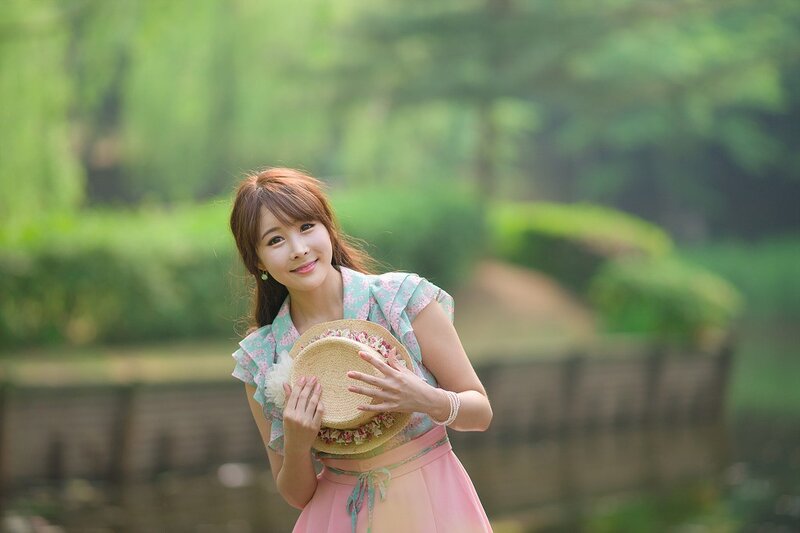 Woman holding hat in garden