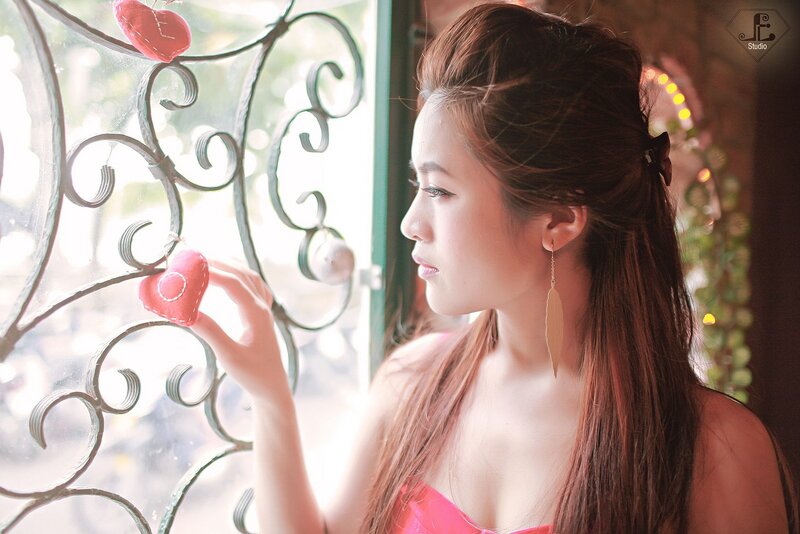 woman holding heart near window