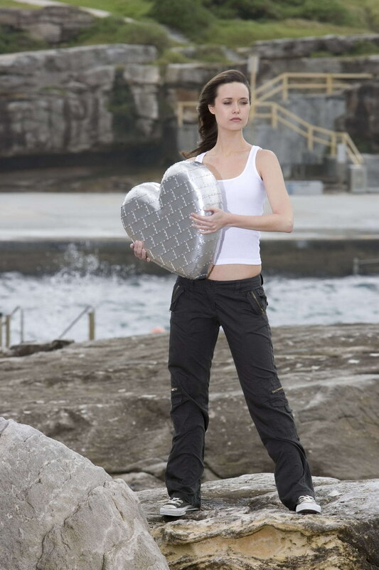 Woman holding heart on rocks
