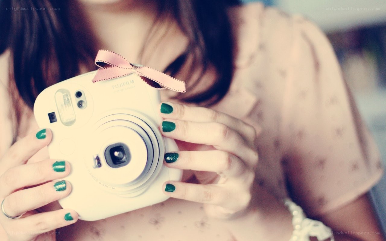 woman holding instant camera