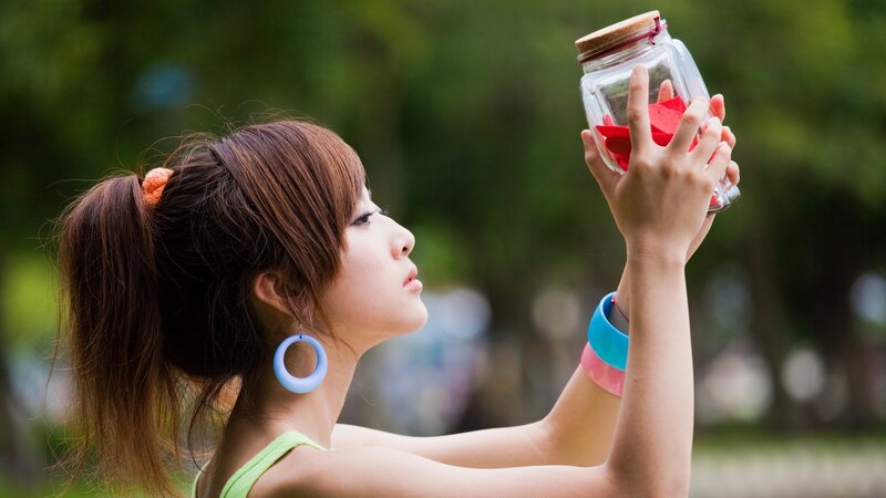 woman holding jar with red paper
