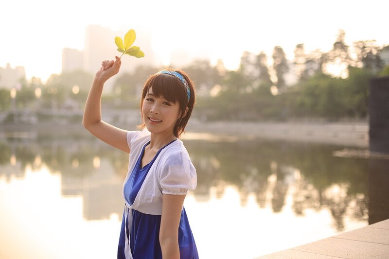 Woman holding leaf by water