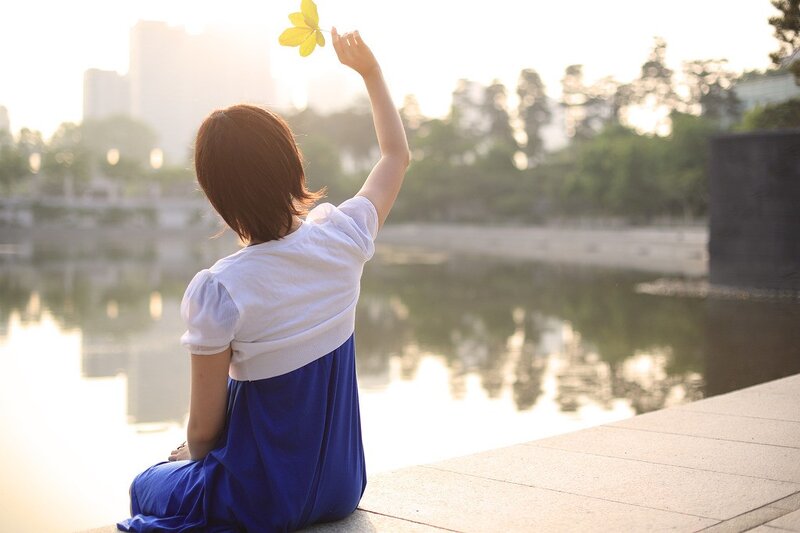 Woman holding leaf by water