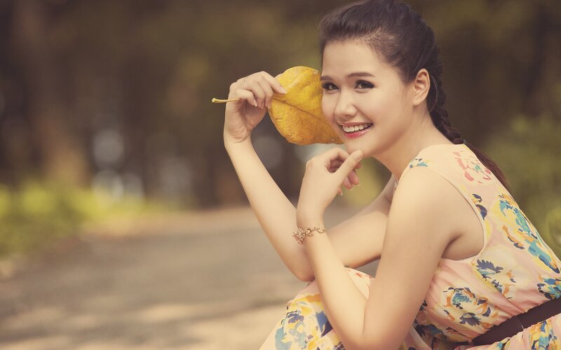 woman holding leaf in park