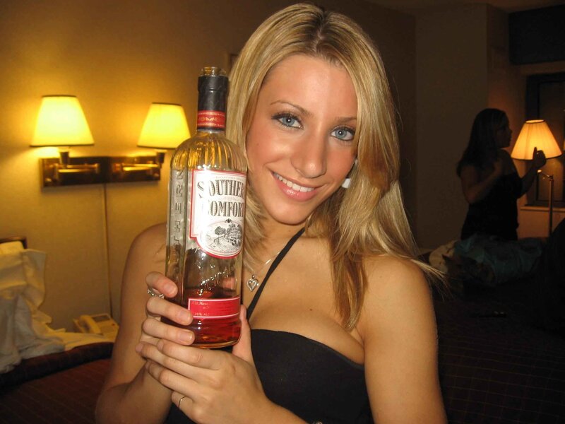 Woman Holding Liquor Bottle — Yellow