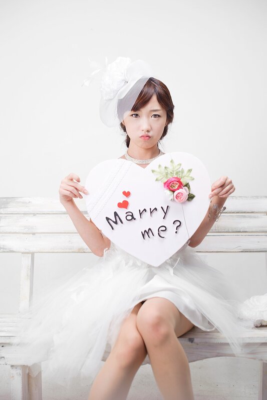 Woman holding 'Marry Me?' sign