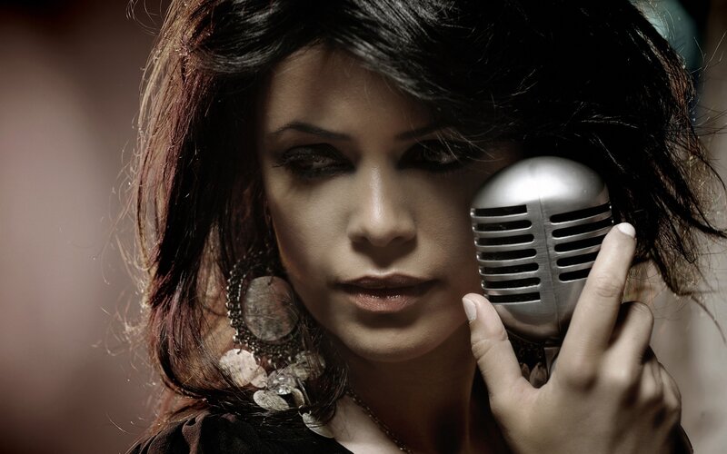 Woman Holding Microphone — Black, Dramatic, Photograph, Earring, Dark Hair