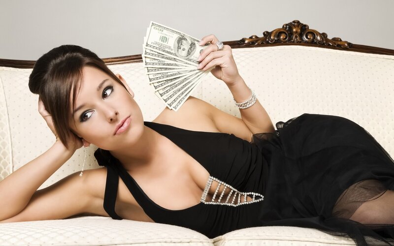 woman holding money on couch