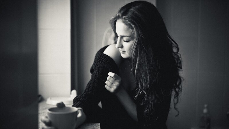 woman holding mug by window