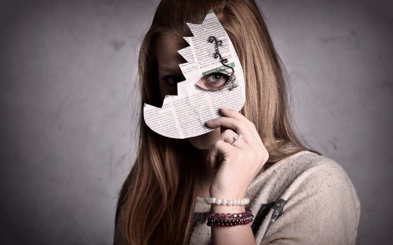 woman holding newspaper mask