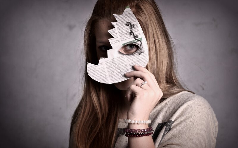 woman holding newspaper mask