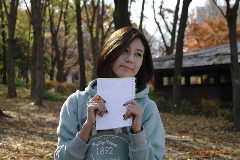 woman holding notebook in park