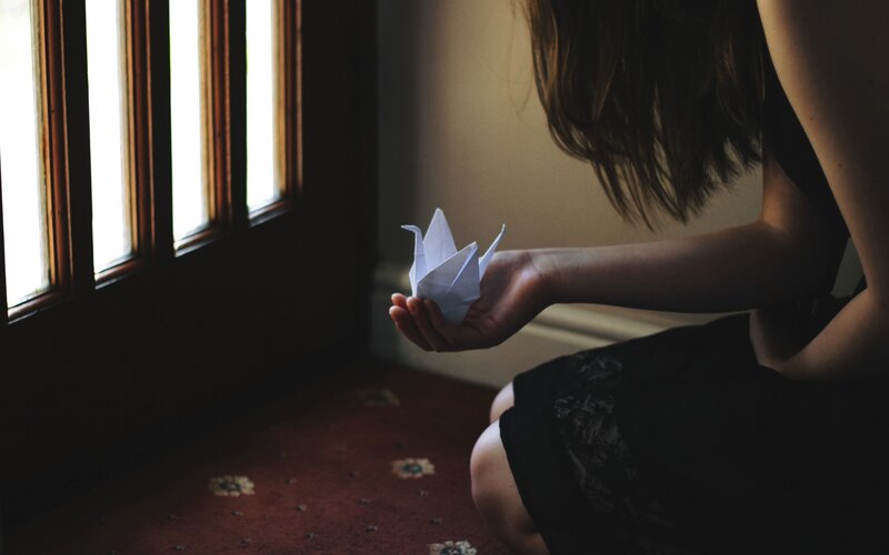woman holding origami crane
