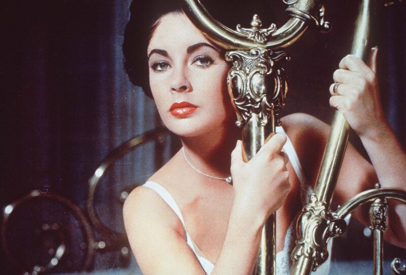 Woman holding ornate mirror