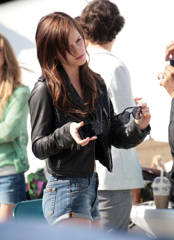 woman holding phone and sunglasses