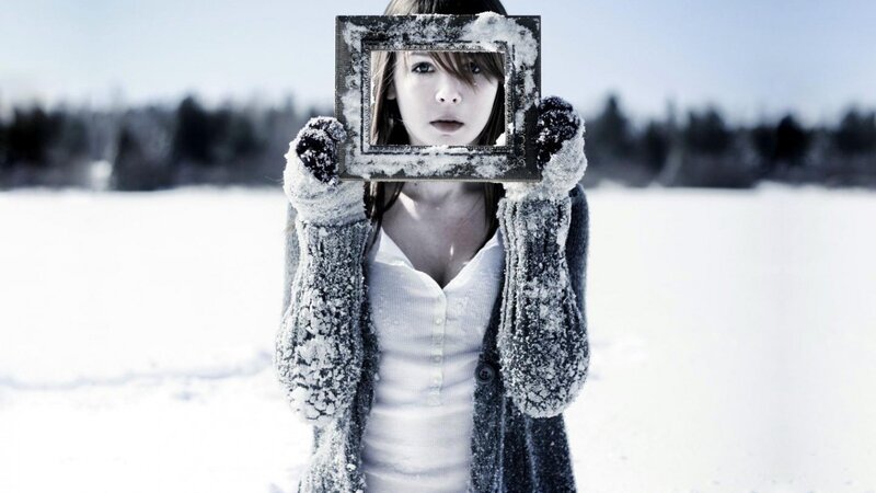 woman holding photo frame in snow