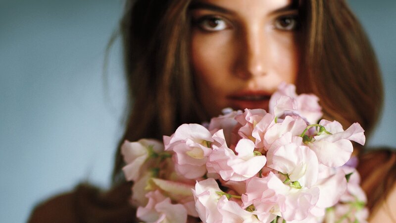 woman holding pink flowers