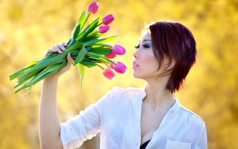 woman holding pink tulips