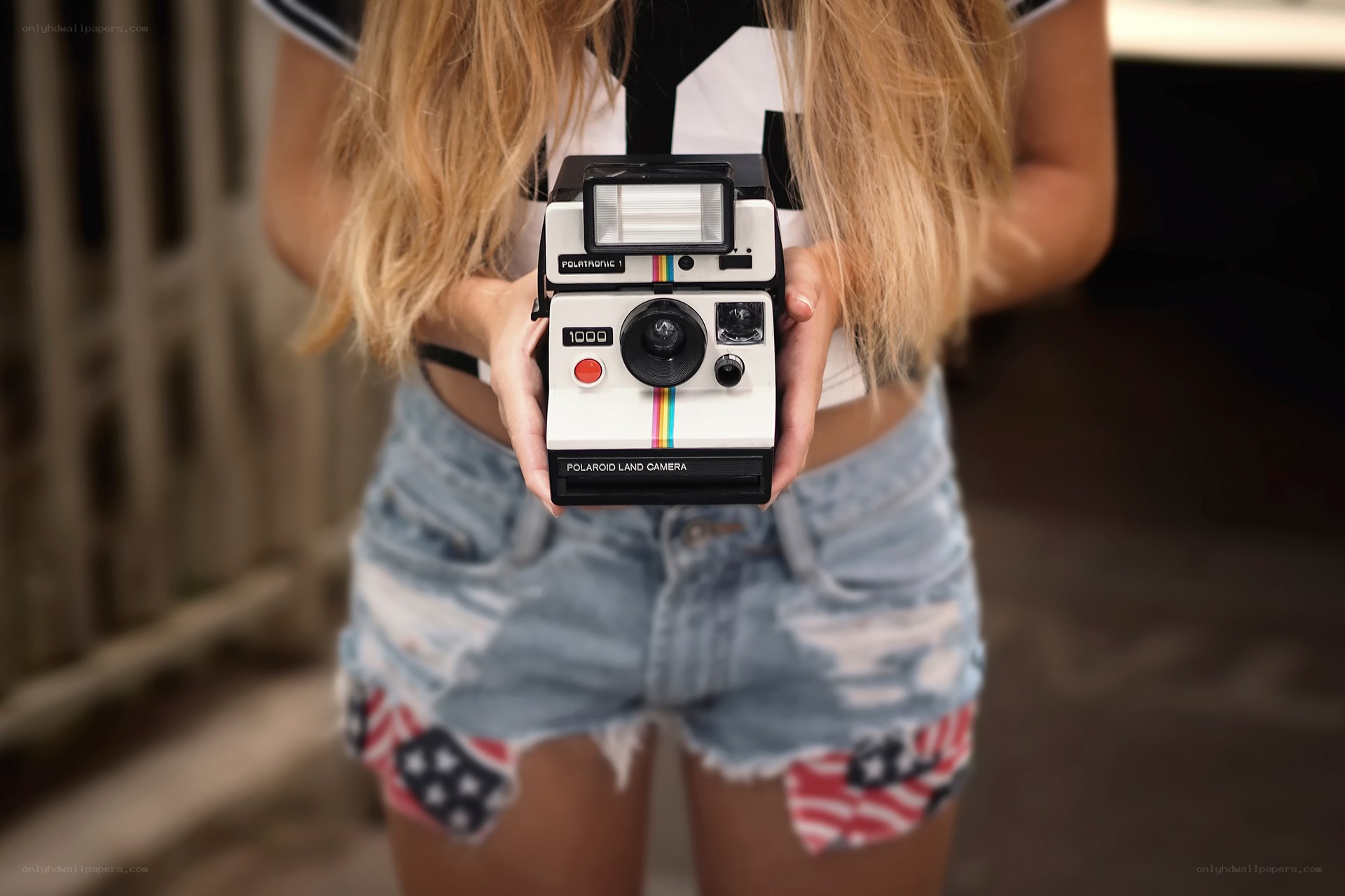woman holding polaroid camera