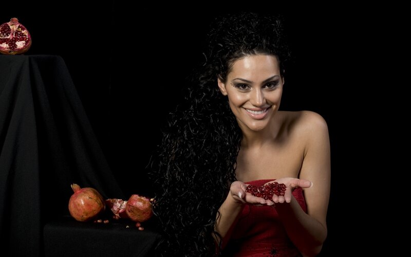 woman holding pomegranate seeds
