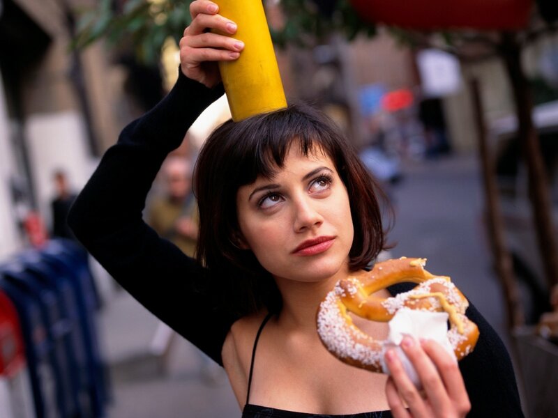 Woman holding pretzel and mustard
