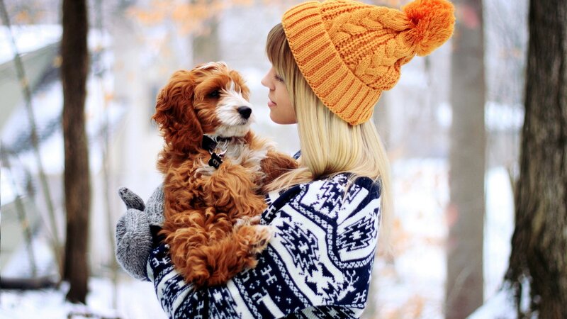 woman holding puppy in winter
