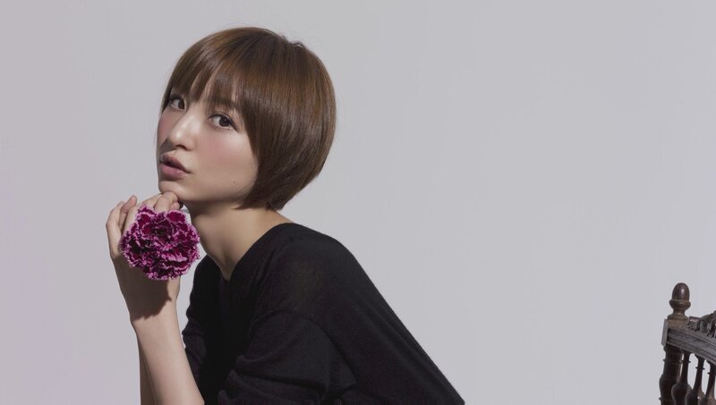 woman holding purple flower