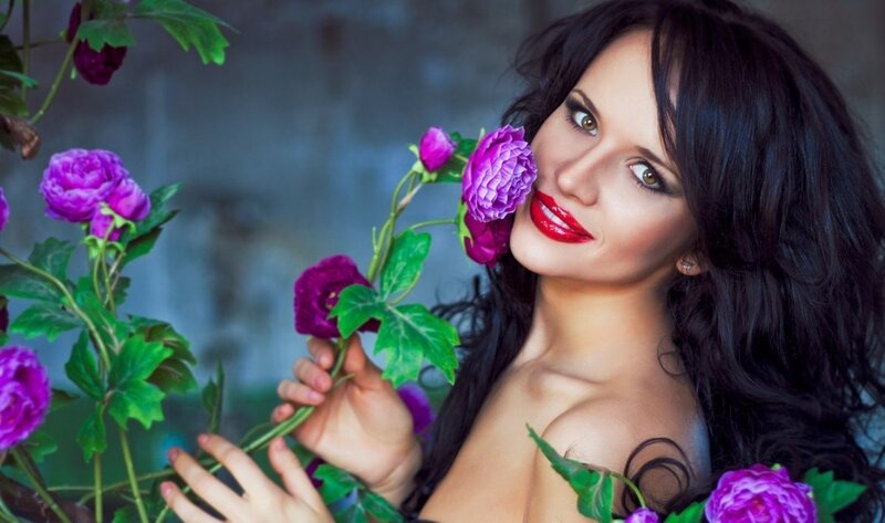 Woman Holding Purple Flowers — Dramatic