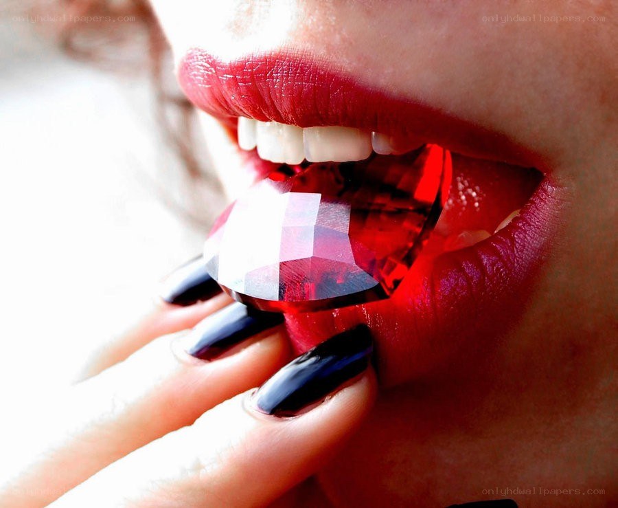 woman holding red gemstone