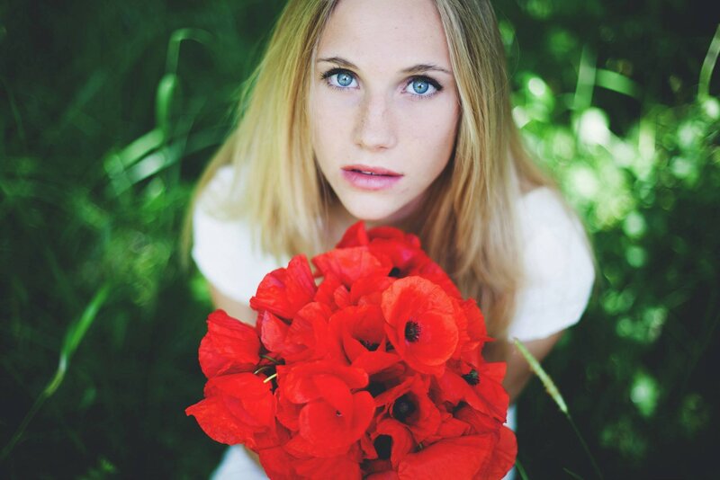 woman holding red poppies