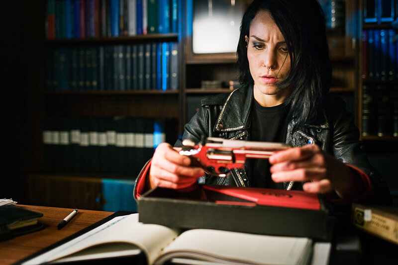 woman holding red revolver