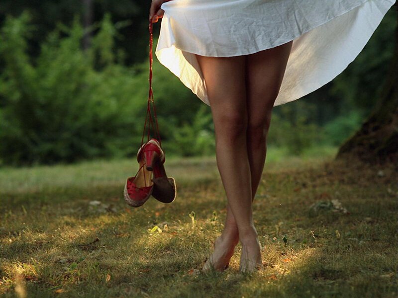 woman holding red shoes