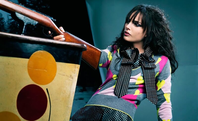 woman holding rifle in colorful outfit