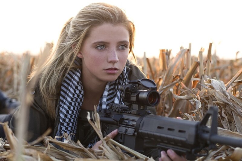 woman holding rifle in field
