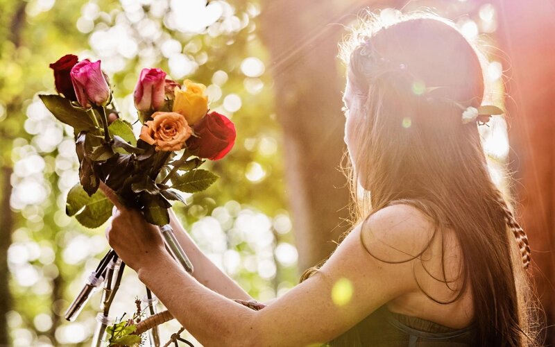 woman holding roses in sunlight