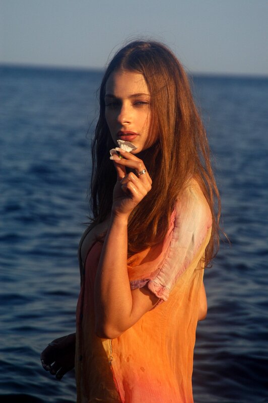 woman holding seashell by sea