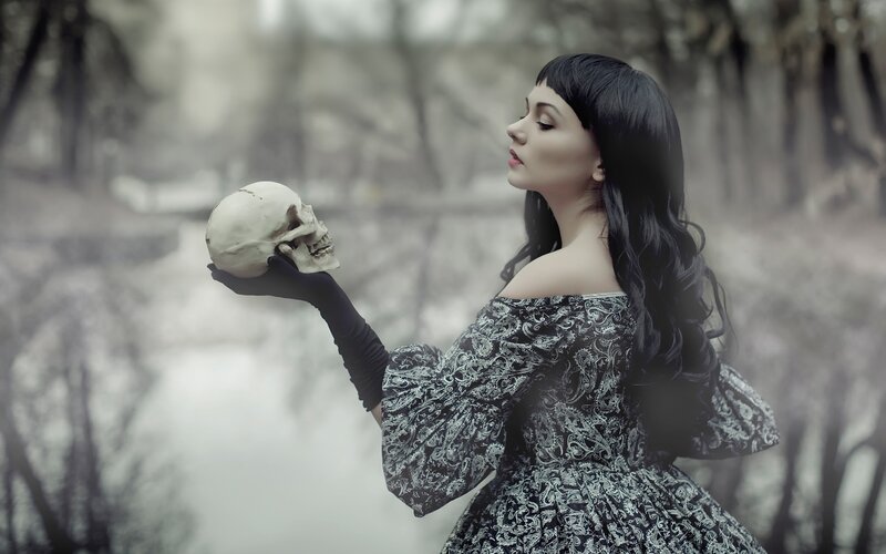 woman holding skull in forest