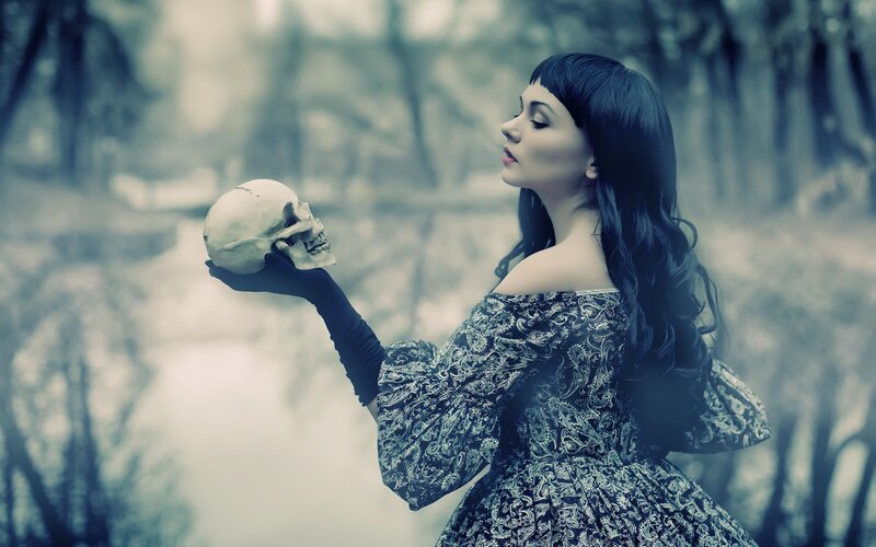 woman holding skull in forest
