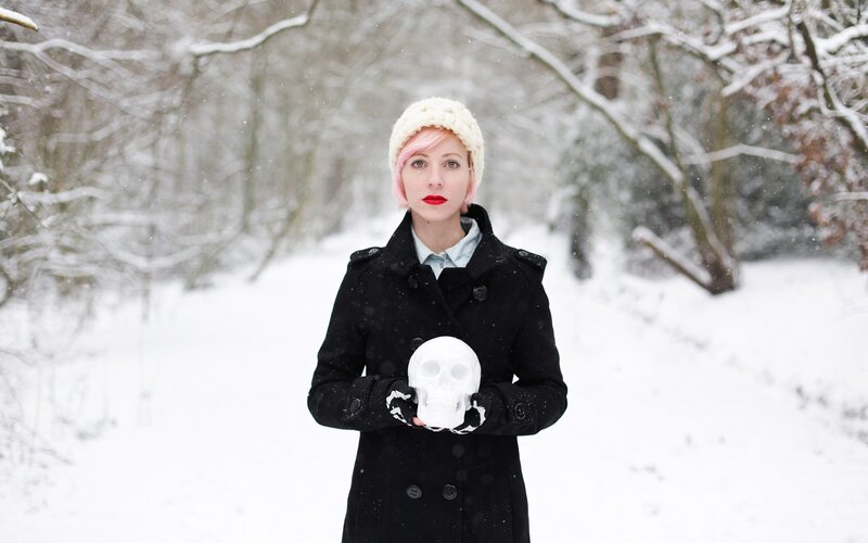 Woman holding skull in snow