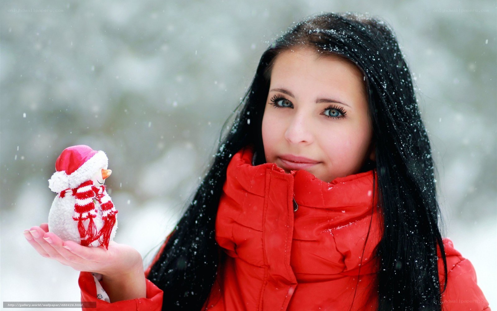 woman holding snowman in snow