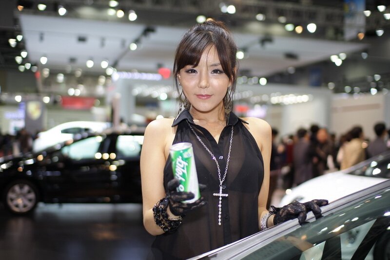 Woman holding soda at auto show