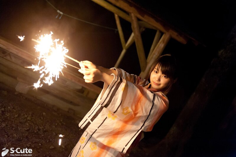 Woman holding sparkler at night
