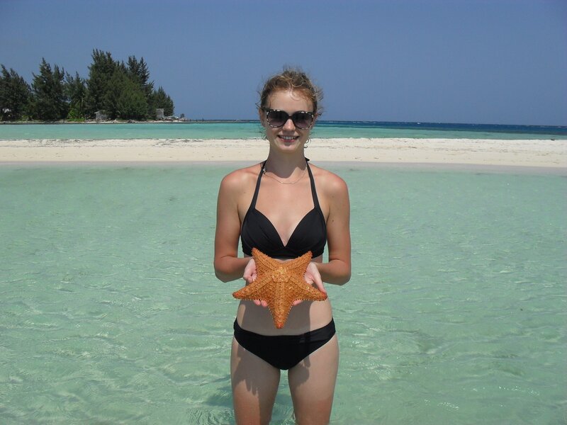 Woman holding starfish at beach