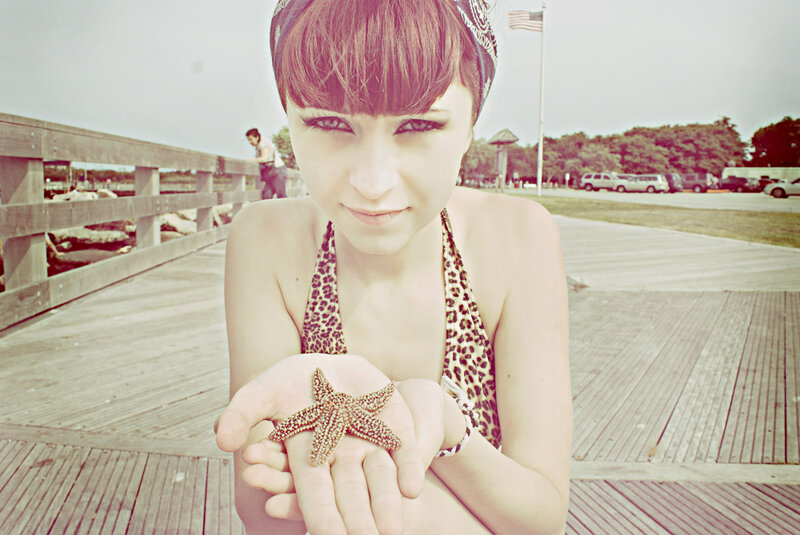 woman holding starfish on pier