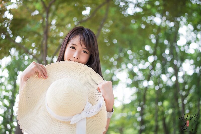woman holding straw hat outdoors